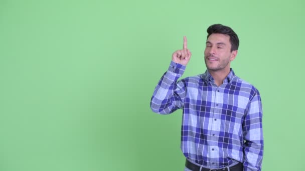 Lycklig ung spansktalande man pekar upp och ger tummen upp — Stockvideo