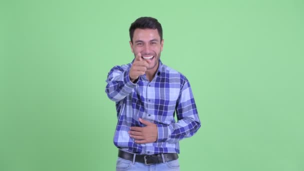Lycklig ung spansktalande man skrattar och pekar på kameran — Stockvideo