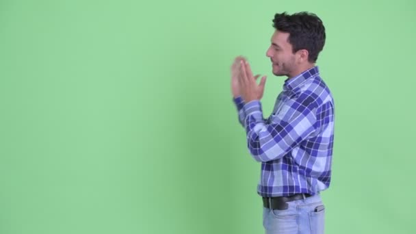 Happy young Hispanic man presenting something to the back — Stock Video