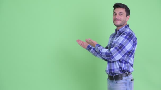 Feliz jovem hispânico homem mostrando para trás e dando polegares para cima — Vídeo de Stock