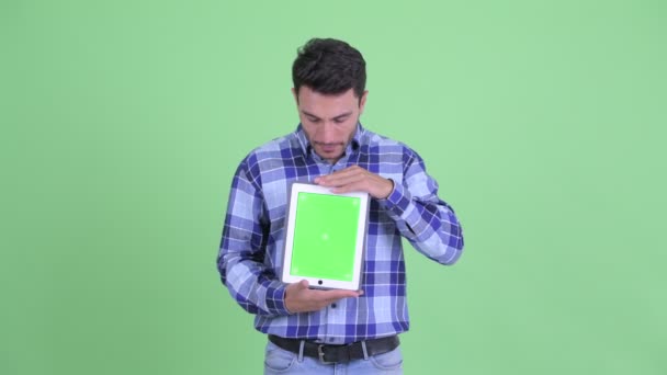 Stressed young Hispanic man showing digital tablet — Stock Video