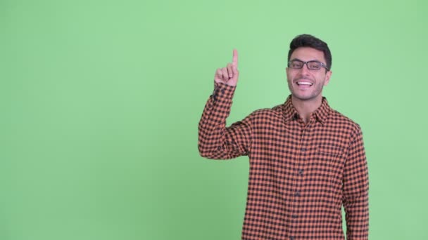 Feliz joven hipster hispano apuntando hacia arriba y dando pulgares hacia arriba — Vídeo de stock