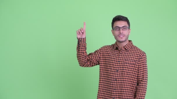 Feliz joven hipster hispano hablando mientras señala hacia arriba — Vídeos de Stock