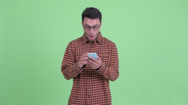Boldog fiatal hispán csípő ember használ telefon és látszó meglepett — Stock videók