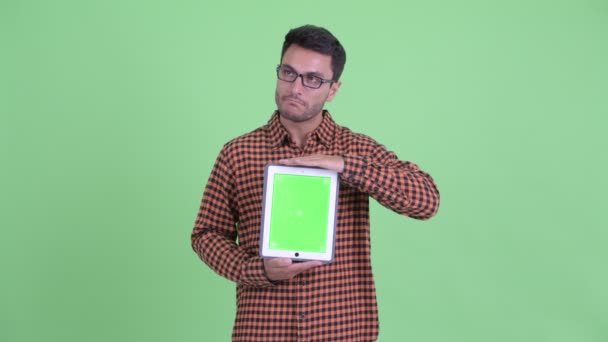 Gestresster junger hispanischer Hipster zeigt digitales Tablet — Stockvideo