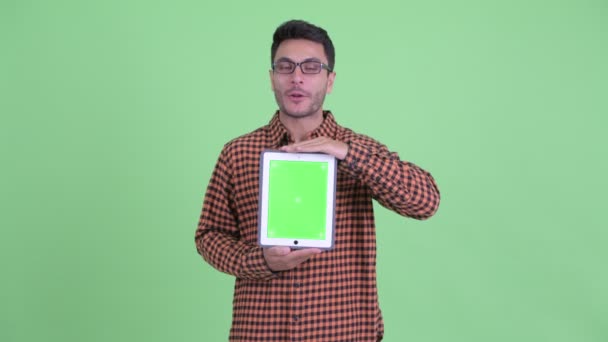 Glücklicher junger hispanischer Hipster-Mann spricht, während er ein digitales Tablet zeigt — Stockvideo