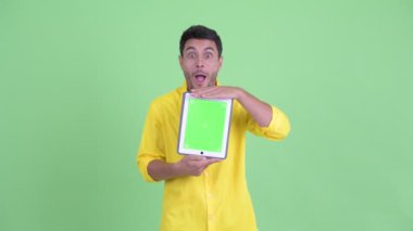 Mutlu genç İspanyol işadamı dijital tablet gösteren ve sürpriz görünümlü