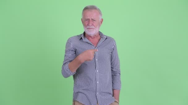 Злий старший бородатий чоловік вказує на камеру — стокове відео