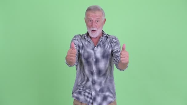 Щасливий старший бородатий чоловік піднімає великі пальці і виглядає схвильованим — стокове відео
