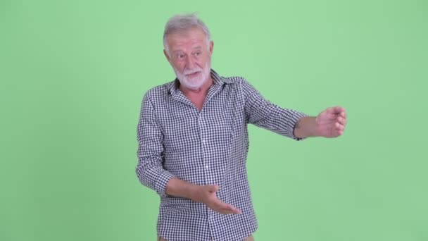 Gelukkige Senior bebaarde man presenteert iets — Stockvideo