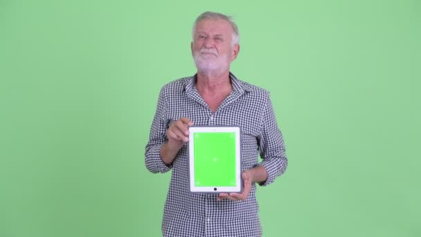 Stressed senior bearded man showing digital tablet and getting bad news — Stock Video