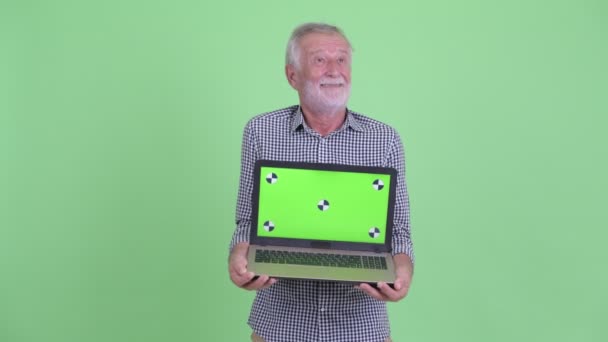 Šťastný starší vousatý muž při zobrazování laptopu — Stock video