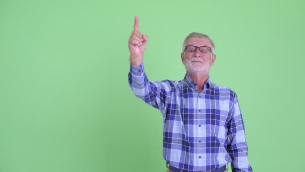 Šťastný starší vousatý muž, který ukazoval nahoru a dává palce — Stock video