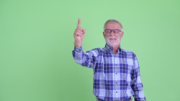 Наголошений старший бородатий хіпстер вказує і віддає великі пальці вниз — стокове відео