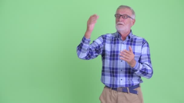 Happy senior bearded hipster man presenting to the back — Stock Video