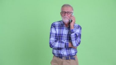 Mutlu kıdemli sakallı hipster adam telefonda konuşurken