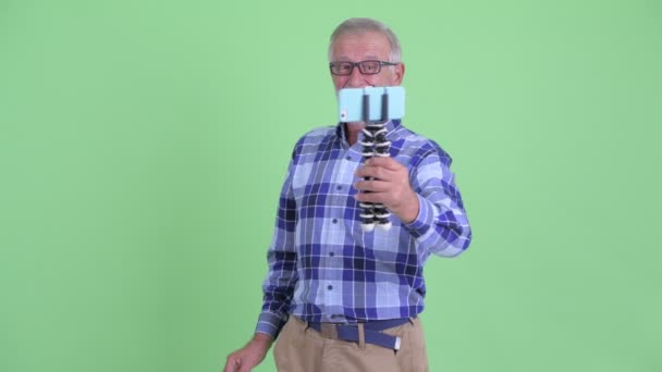 Šťastný starší vousatý muž vloguje a zobrazuje telefon — Stock video