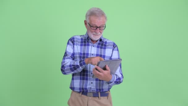 Boldog Senior szakállas csípő ember segítségével digitális tabletta — Stock videók