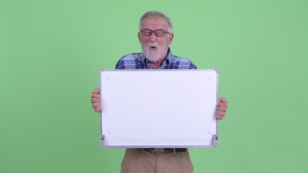 Glücklicher älterer, bärtiger Hipster-Mann spricht, während er ein Whiteboard hält — Stockvideo