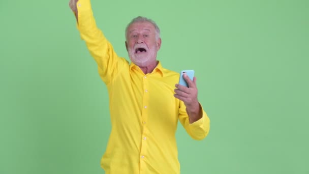 電話を使用して、良いニュースを得て幸せな先輩ひげのビジネスマン — ストック動画