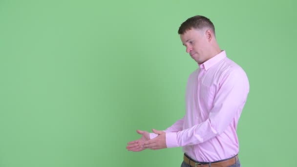 Портрет стрессового бизнесмена, показывающего что-то и показывающего большие пальцы — стоковое видео
