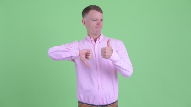 親指と親指の間で選択混乱したビジネスマン — ストック動画