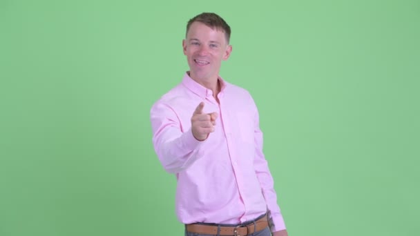 Retrato de un hombre de negocios feliz apuntando a la cámara — Vídeos de Stock