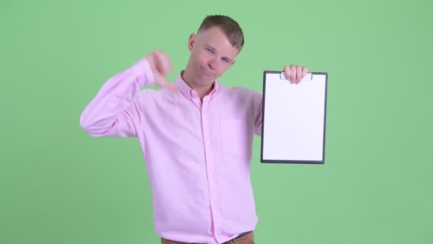 Portret van beklemtoonde zakenman die Klembord toont en duimen naar beneden geeft — Stockvideo