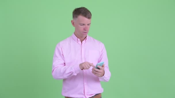Щасливий бізнесмен використовує телефон і отримує хороші новини — стокове відео