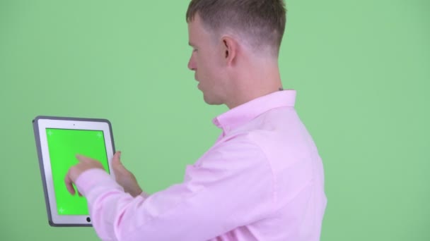 Крупним планом вид ззаду щасливого бізнесмена за допомогою цифрового планшета — стокове відео