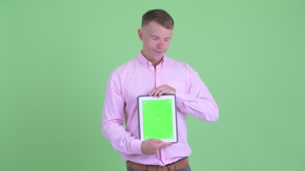 Наголошений бізнесмен показує цифровий планшет і отримує погані новини — стокове відео