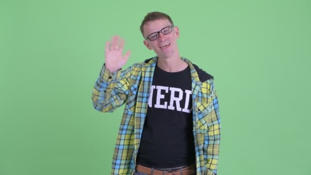 Hombre nerd feliz con anteojos agitando la mano — Vídeo de stock