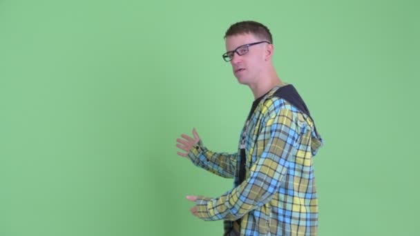 Retrato de homem nerd feliz apresentando para as costas — Vídeo de Stock