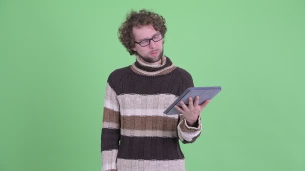 Hombre barbudo joven estresado usando tableta digital y recibiendo malas noticias — Vídeos de Stock