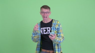 Telefon kullanarak ve şaşırmış görünümlü mutlu nerd adam Portresi