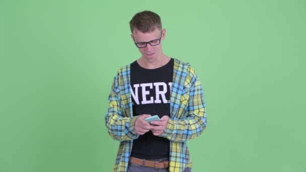 Porträtt av Happy Nerd man med telefon och få goda nyheter — Stockvideo