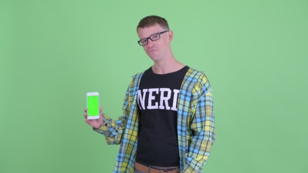 Portret van Happy nerd man praten terwijl het tonen van de telefoon — Stockvideo