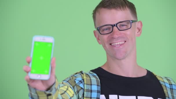 Obličej šťastného nerdmana ukazující telefon — Stock video