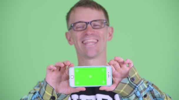 Obličej šťastného nerdmana ukazující telefon — Stock video