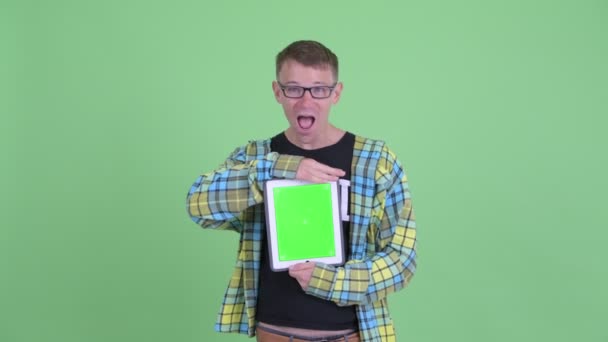 Portret van Happy nerd man toont digitale Tablet en op zoek verrast — Stockvideo
