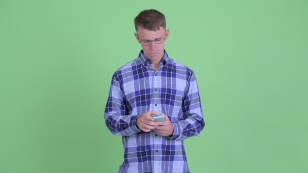 Telefon kullanırken mutlu hipster adam düşünme Portresi — Stok video