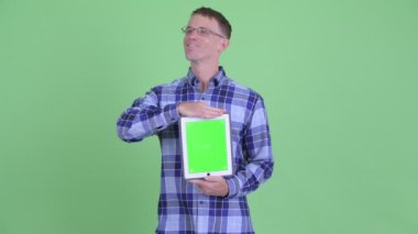 Dijital tablet gösterirken mutlu hipster adam düşünme portresi