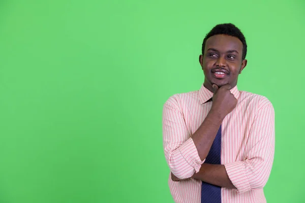 Glücklicher junger afrikanischer Geschäftsmann, der denkt und aufschaut — Stockfoto