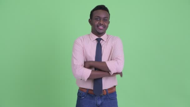 Boldog fiatal afrikai üzletember, mosolygós, keresztbe — Stock videók