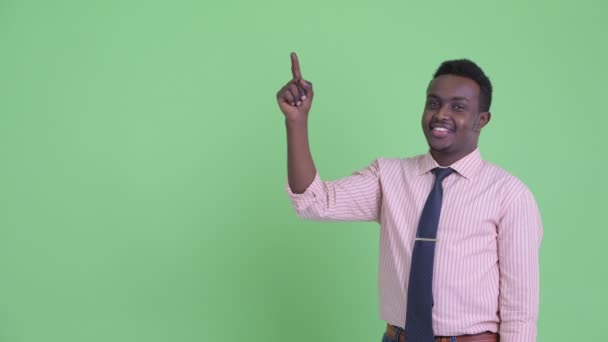 Šťastný mladý africký obchodník ukazující nahoru — Stock video