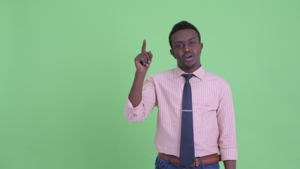 Allvarliga unga afrikanska affärsman pratar samtidigt som pekar uppåt — Stockvideo
