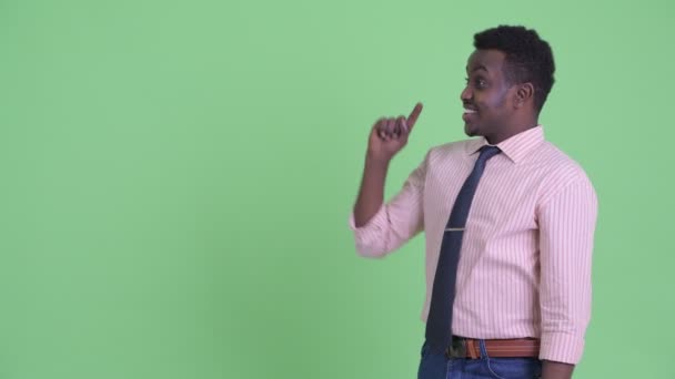 Feliz joven empresario africano tocando algo y mirando sorprendido — Vídeo de stock