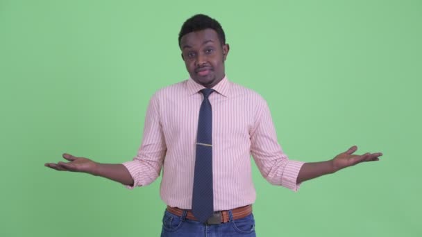 Verward jonge Afrikaanse zakenman afschudden schouders — Stockvideo