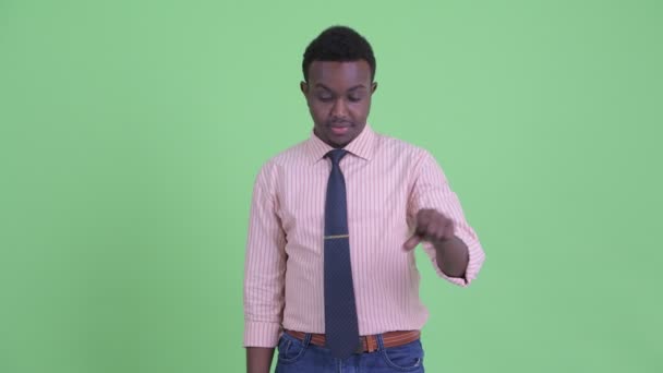Грустный молодой африканский бизнесмен подает большие пальцы — стоковое видео
