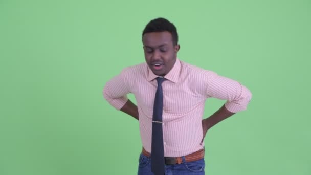 Stressed young African businessman having back pain — Stock Video